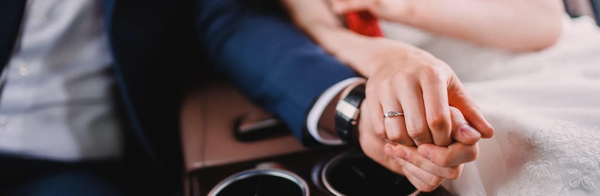 Close-up of a newly wed couple riding in high class car.