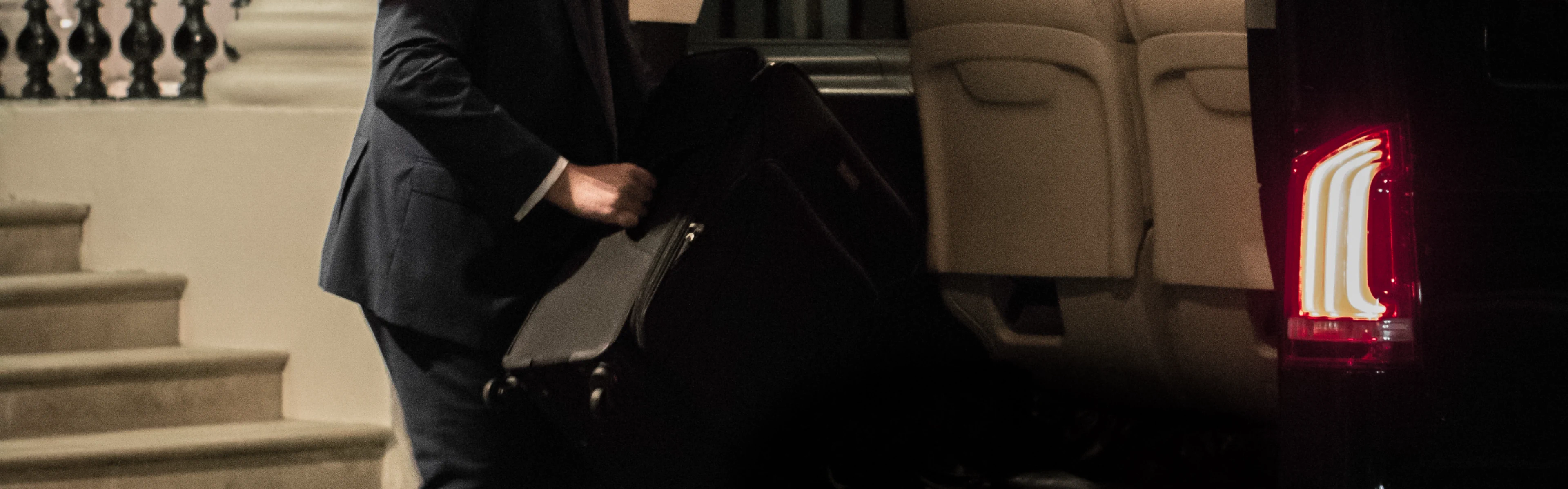 Luxury airport transfers in London Your Chauffeur placing multiple bags in the back of an MPV.