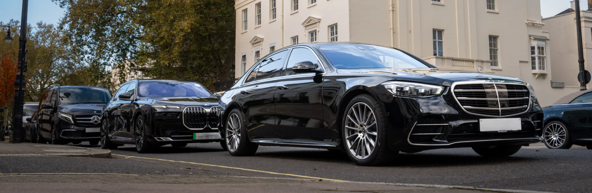 Exclusive cars waiting for passengers in front of event hosting establishment.
