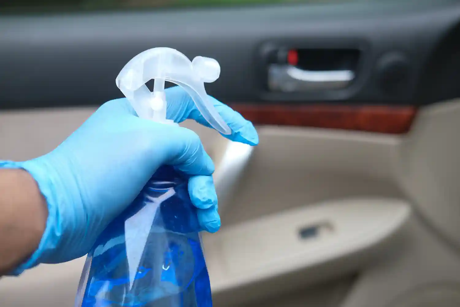 Spraying the interior of a luxury car with a disinfectant
